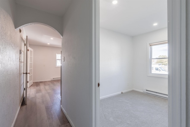 hall with light hardwood / wood-style floors and a baseboard radiator