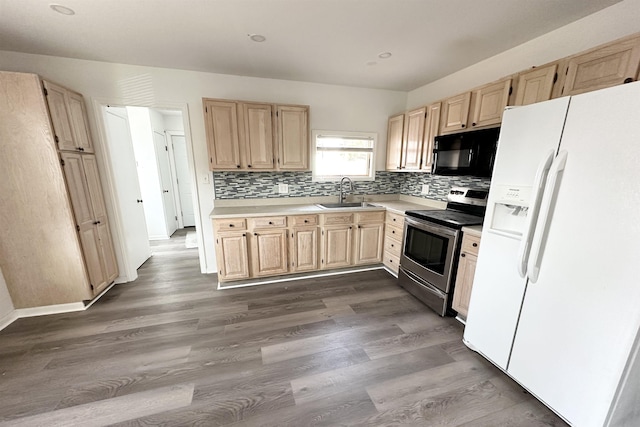 kitchen with white refrigerator with ice dispenser, sink, dark wood-type flooring, stainless steel electric stove, and light brown cabinetry