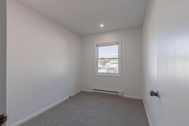 spare room with baseboard heating and carpet