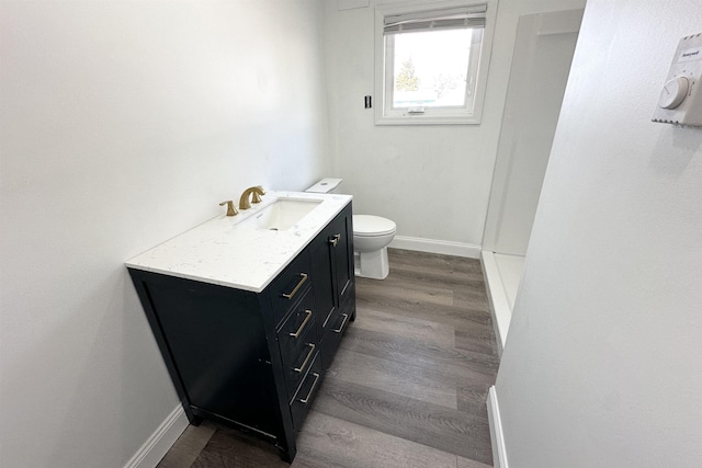 bathroom featuring toilet, vanity, and hardwood / wood-style floors