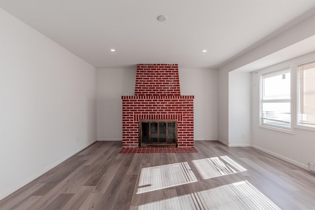 unfurnished living room with a fireplace and hardwood / wood-style floors