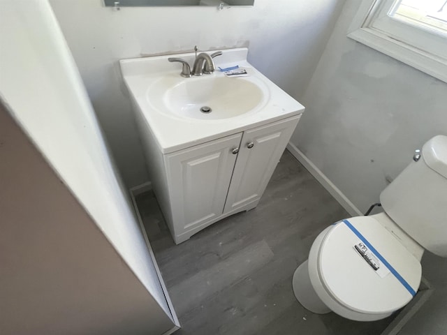 bathroom with vanity, wood-type flooring, and toilet