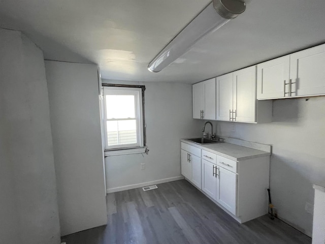 kitchen with radiator, sink, white cabinets, and hardwood / wood-style floors