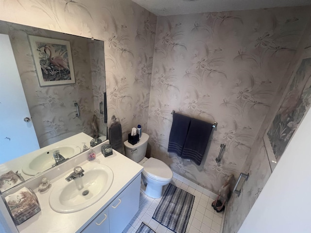 bathroom featuring tile patterned floors, toilet, vanity, and wallpapered walls