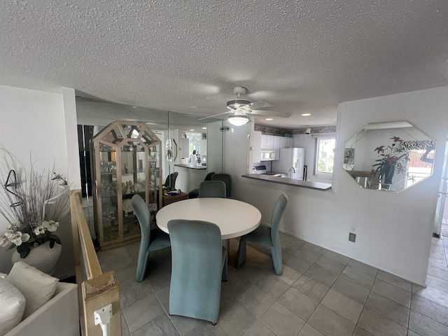 dining room with a ceiling fan and a textured ceiling