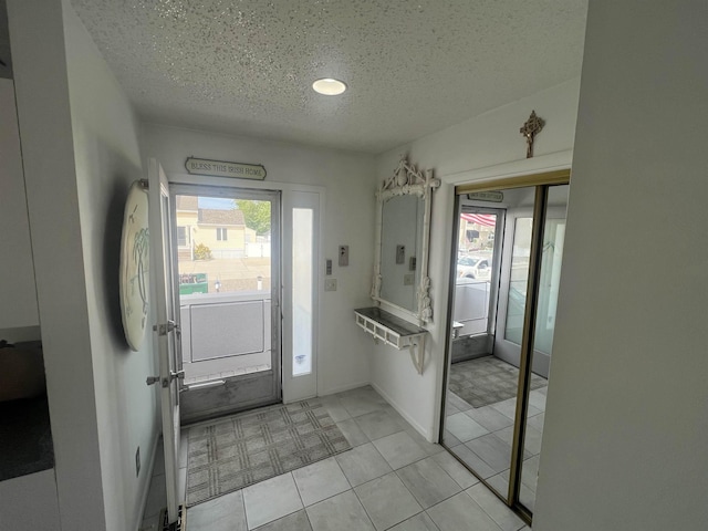 entrance foyer featuring a textured ceiling and light tile patterned floors