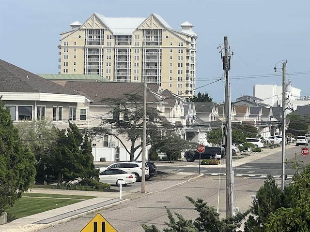 view of asphalt street with traffic signs, sidewalks, and curbs