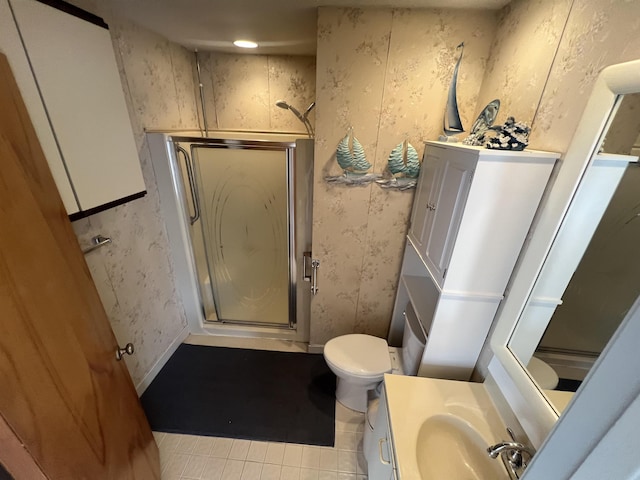 full bathroom with a stall shower, wallpapered walls, toilet, vanity, and tile patterned flooring