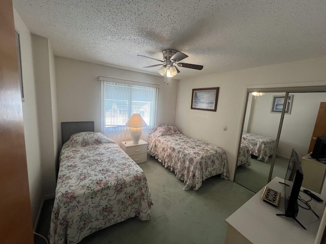 carpeted bedroom with a textured ceiling, ceiling fan, and a closet