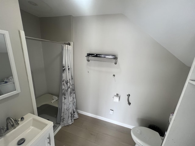 full bathroom with a sink, toilet, curtained shower, vaulted ceiling, and baseboards