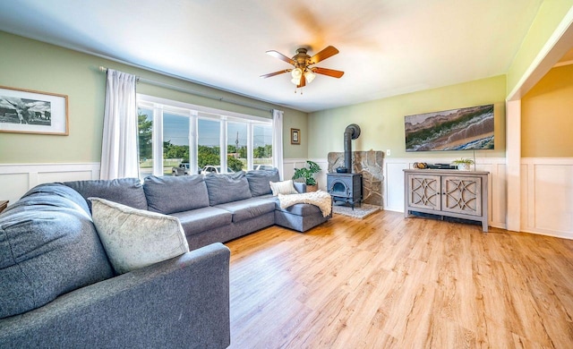 1731 Rte 47, Eldora, NJ 08270 - living room featuring a wainscoted wall, a wood stove, light wood-type flooring, a ceiling fan, and a decorative wall
