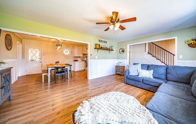 1731 Rte 47, Eldora, NJ 08270 - living room featuring a wainscoted wall, ceiling fan, light wood-style flooring, a decorative wall, and stairs