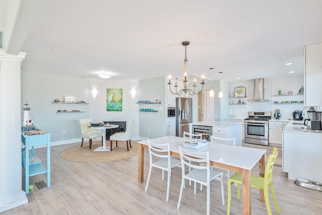 dining area featuring beverage cooler, light wood-type flooring, and a notable chandelier