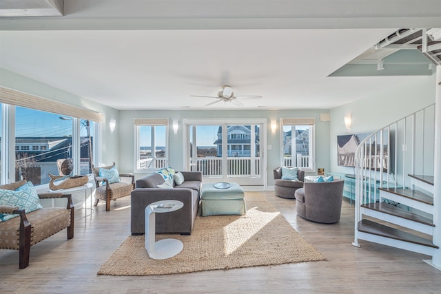 living room featuring ceiling fan, a healthy amount of sunlight, and light wood-type flooring