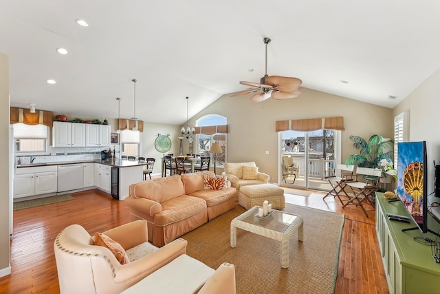 living room with light wood-style flooring, vaulted ceiling, a ceiling fan, and recessed lighting