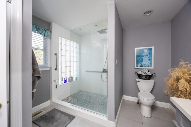 bathroom featuring a tile shower, vanity, tile patterned floors, and toilet