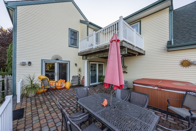 rear view of house featuring a balcony, a hot tub, and a patio area