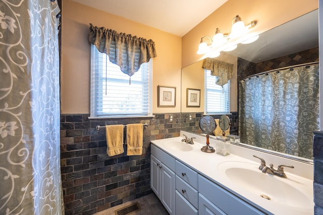 bathroom featuring vanity and tile walls