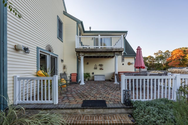 rear view of property featuring a balcony and a patio