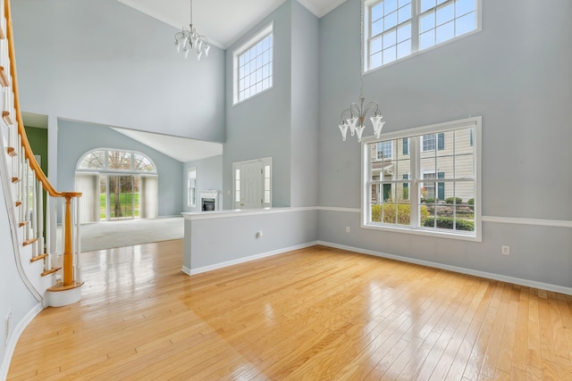 702 Turnberry Ct Unit C0031, Swainton, NJ 08210 - unfurnished living room with a chandelier, high vaulted ceiling, wood-type flooring, baseboards, and stairway