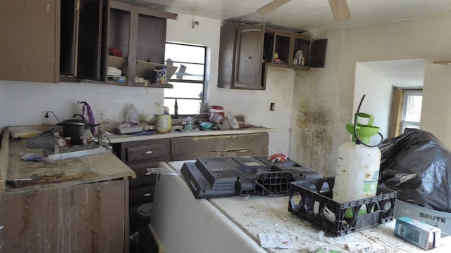 kitchen featuring light countertops, ceiling fan, and dark brown cabinets