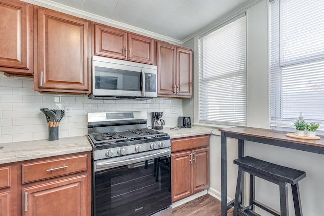 222 E Burk Ave Unit 5, Wildwood, NJ 08260 - kitchen with brown cabinetry, backsplash, dark wood finished floors, and stainless steel appliances