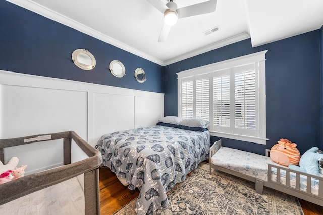 243 110th St, Stone Harbor, NJ 08247 - bedroom with a decorative wall, wood finished floors, ornamental molding, a wainscoted wall, and ceiling fan