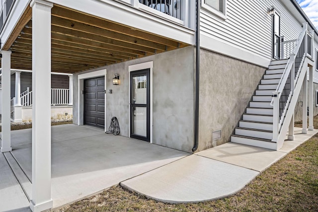 view of patio / terrace with a garage and stairway