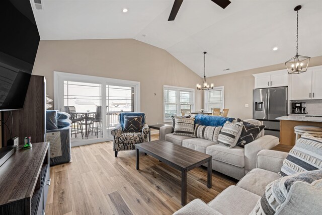 living area featuring visible vents, light wood-style flooring, ceiling fan with notable chandelier, vaulted ceiling, and recessed lighting