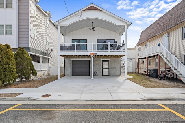 view of front of home with stairs, concrete driveway, an attached garage, and a ceiling fan