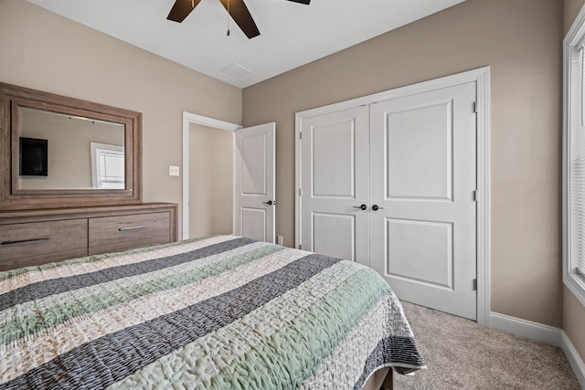 carpeted bedroom featuring a closet, ceiling fan, and baseboards