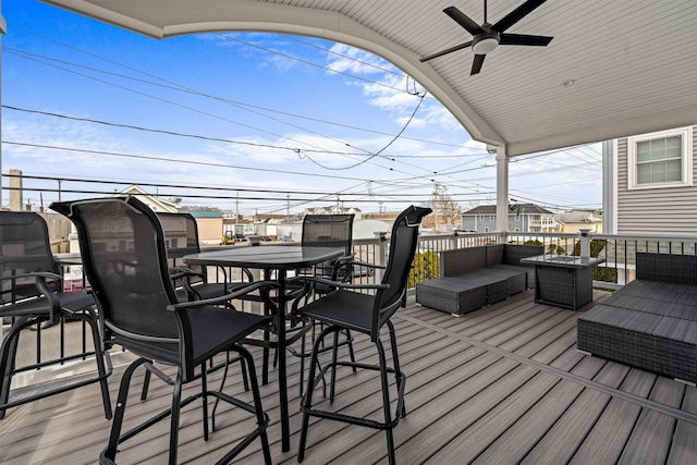 wooden terrace featuring outdoor dining area, ceiling fan, and an outdoor living space