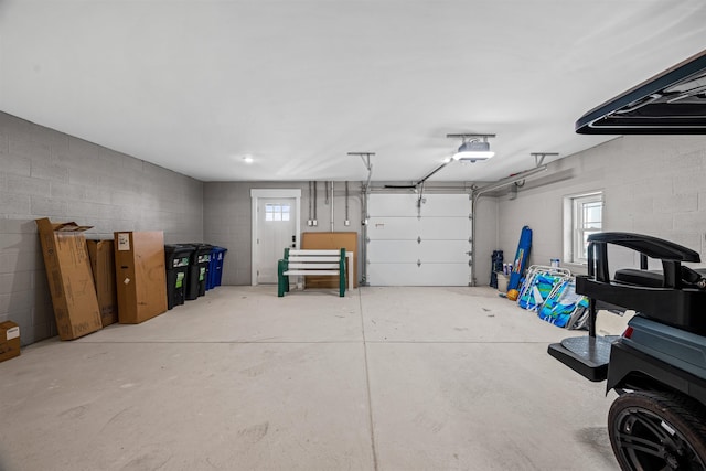 garage featuring a garage door opener and concrete block wall