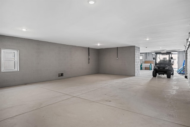 garage with concrete block wall and recessed lighting