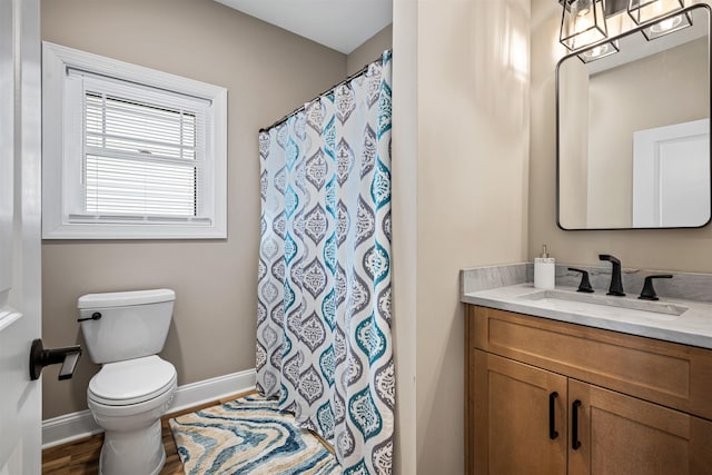 full bath featuring curtained shower, toilet, vanity, wood finished floors, and baseboards