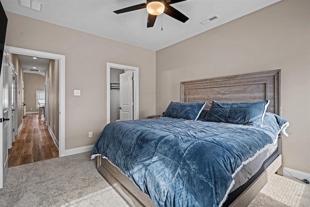 carpeted bedroom featuring a ceiling fan, visible vents, and baseboards