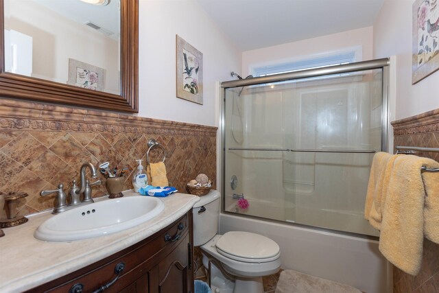 full bathroom with shower / bath combination with glass door, vanity, and toilet