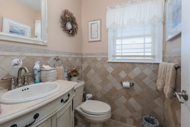 bathroom featuring vanity, toilet, and tile walls