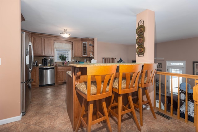 kitchen featuring tasteful backsplash, kitchen peninsula, and appliances with stainless steel finishes