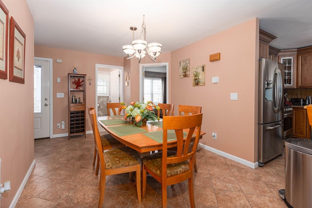 dining area with light tile patterned floors and a notable chandelier