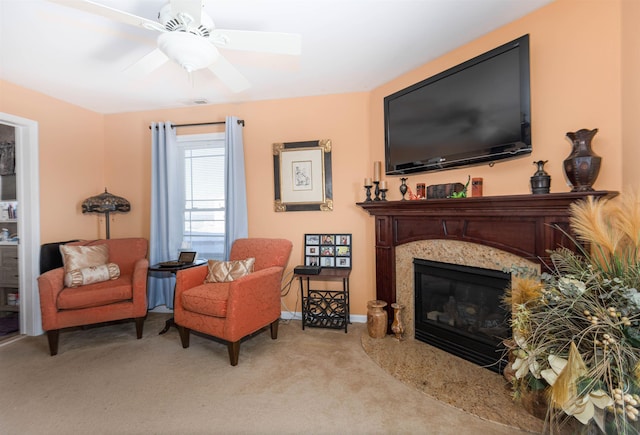 living area with ceiling fan, light colored carpet, and a fireplace