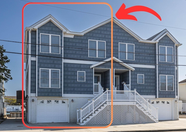 view of front of home featuring central AC, a porch, and a garage