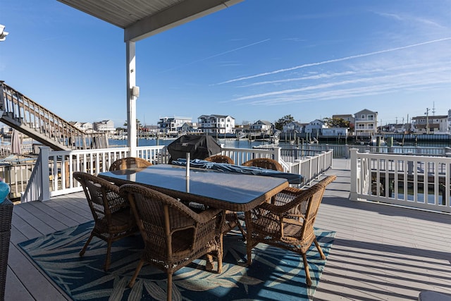 wooden terrace with a grill and a water view