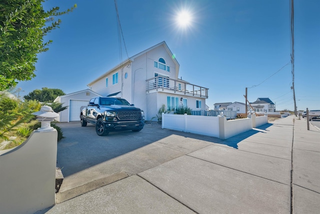 view of property exterior with a balcony, a garage, and an outdoor structure