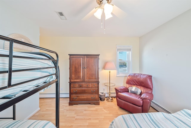 bedroom featuring light hardwood / wood-style floors, baseboard heating, and ceiling fan