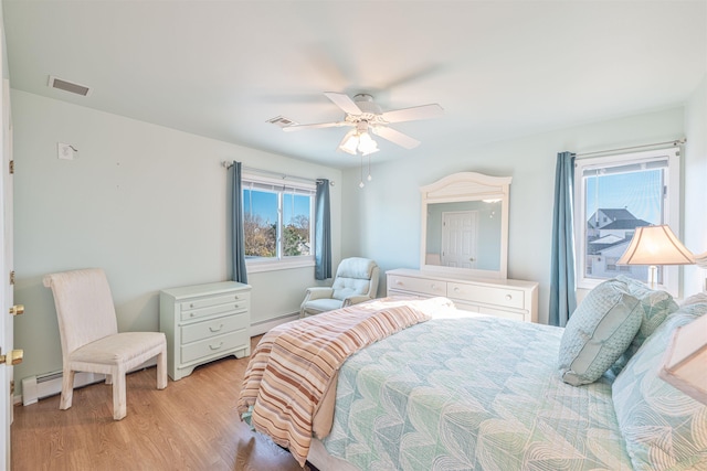 bedroom with ceiling fan, baseboard heating, and light hardwood / wood-style flooring