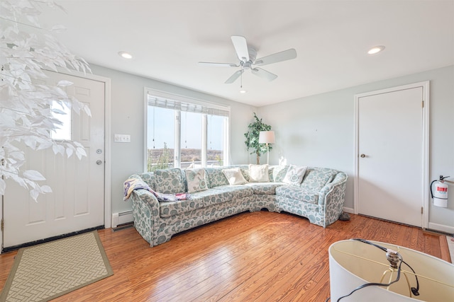 living room with ceiling fan, light wood-type flooring, and baseboard heating