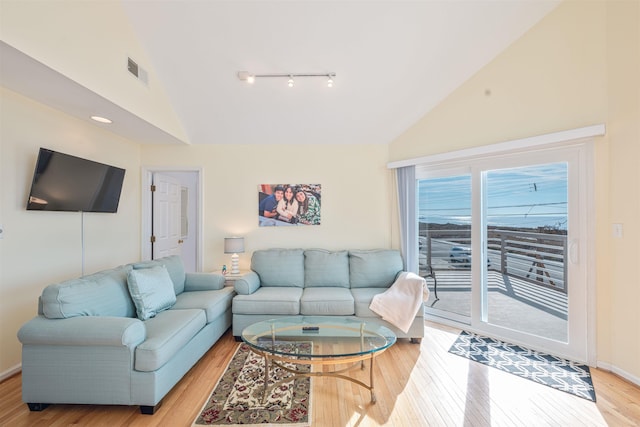 living room featuring light hardwood / wood-style flooring and high vaulted ceiling