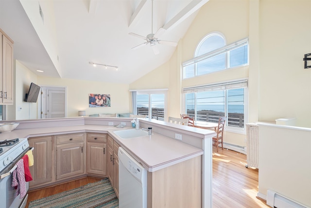 kitchen featuring light brown cabinets, white appliances, a baseboard heating unit, and sink