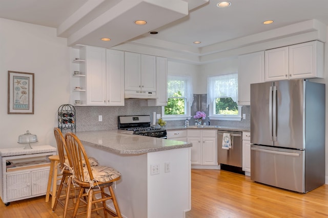 119 Stevens St, West Cape May, NJ 08204 - kitchen featuring appliances with stainless steel finishes, under cabinet range hood, white cabinetry, a peninsula, and recessed lighting
